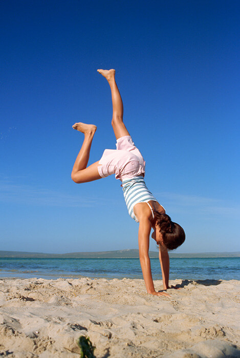 woman handstand exit on beach
